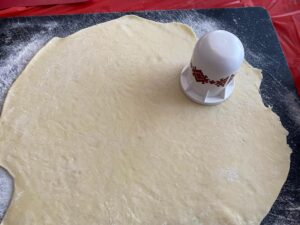 perogy dough rolled out on cutting board with perogy cutter