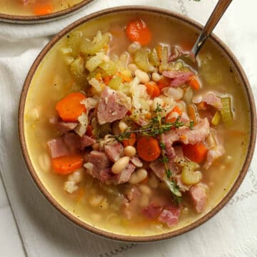 Ham and Bean soup in a brown bowl on white surface