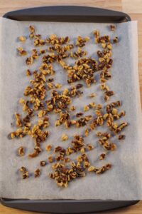 walnuts on parchment covered baking sheet
