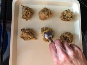 cookies being dropped by tablespoon onto cookie sheet