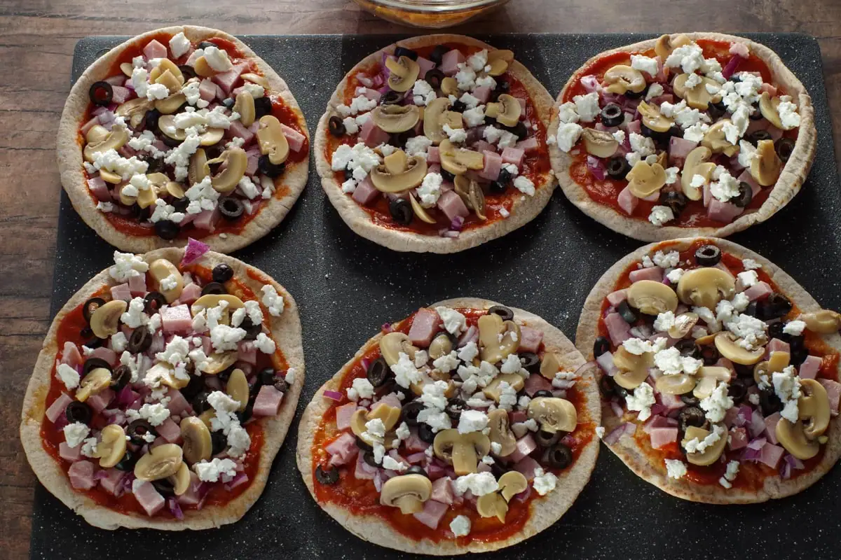 mushrooms, black olives, feta cheese and onion sprinkled on pita pizzas
