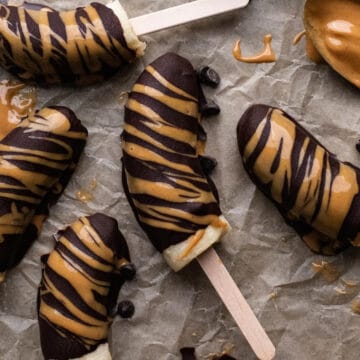 Frozen chocolate covered bananas on parchment paper