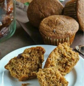 broken pieces of Healthy Date Bran muffin on a white plate with more muffins in the background