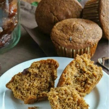 broken pieces of Healthy Date Bran muffin on a white plate with more muffins in the background