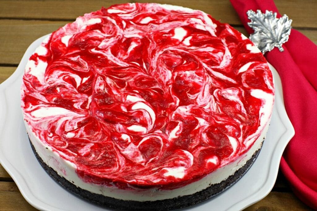 Whole no bake strawberry rhubarb cheesecake on a plate