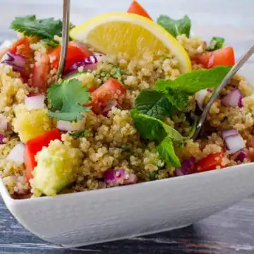 quinoa salad with spoon sticking out, in white bowl