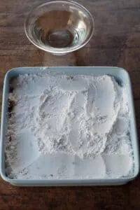 icing sugar cornstarch mixture poured over rhubarb and cake batter