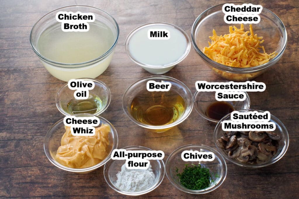ingredients for beer cheese soup in glass bowls, labelled, on brown faux wood surface