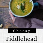 fiddlehead soup in a mug with a spoon, with hands holding it