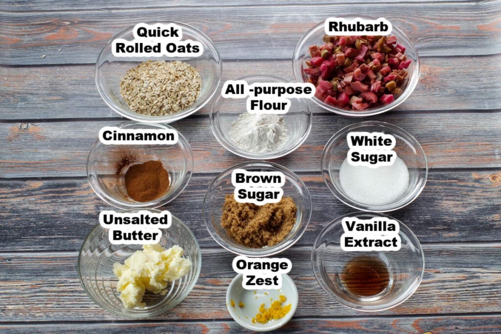 ingredients for microwave rhubarb crisp in a mug on a faux wooden surface, in glass bowls, labelled