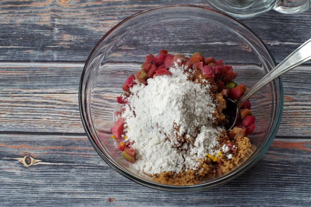 rhubarb, brown sugar, white sugar, flour, vanilla extract and orange zest in a glass bowl