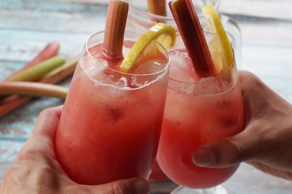 rhubarb lemonade in two glasses being clinked together