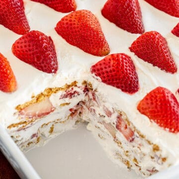 strawberry icebox cake in a white rectangular dish (with a piece missing)