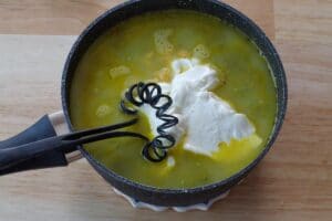 cheese, greek yogurt, milk being whisked into soup