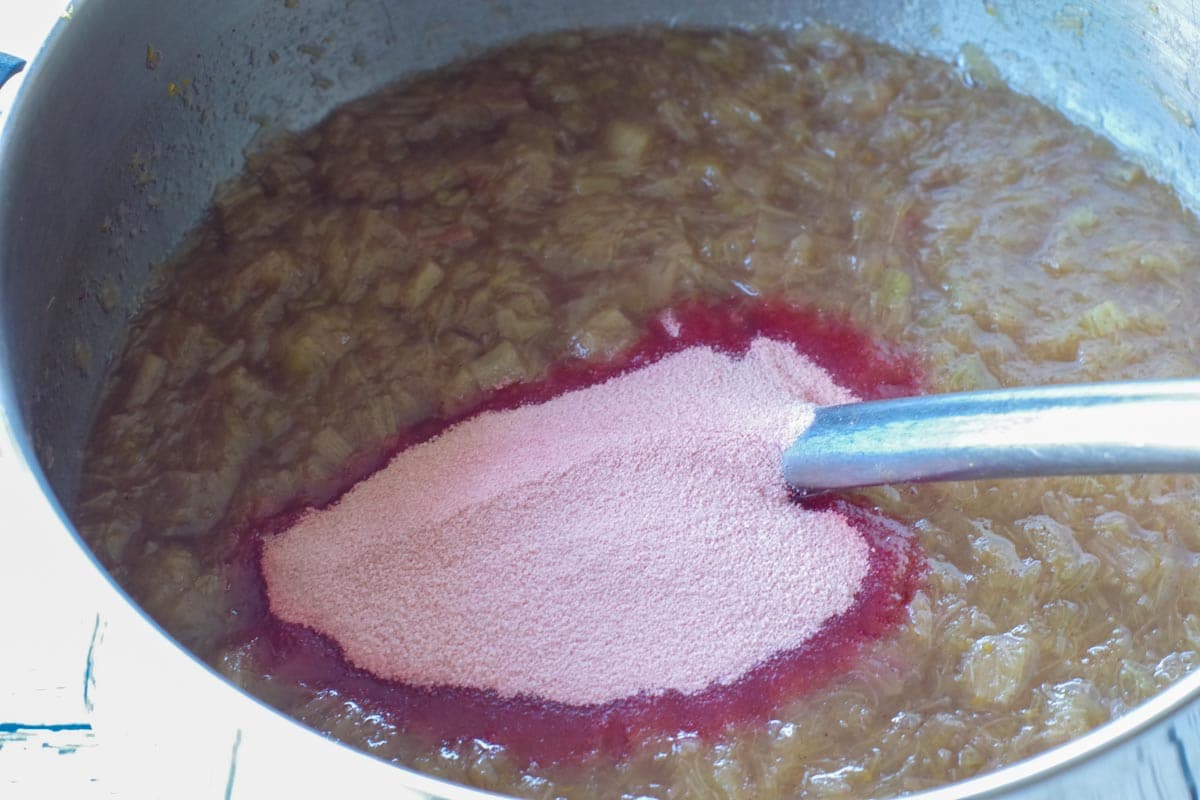 stewed rhubarb in a saucepan with dry strawberry gelatin added