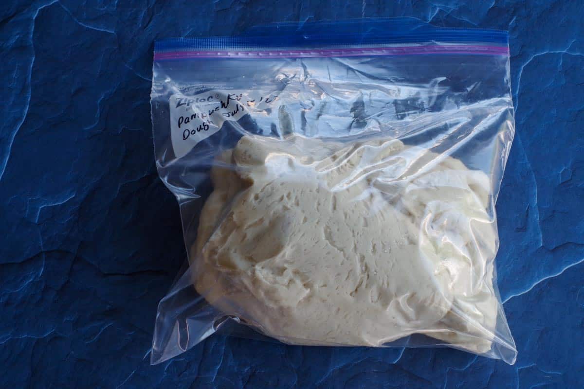 pampushky dough in labelled freezer bag on blue surface
