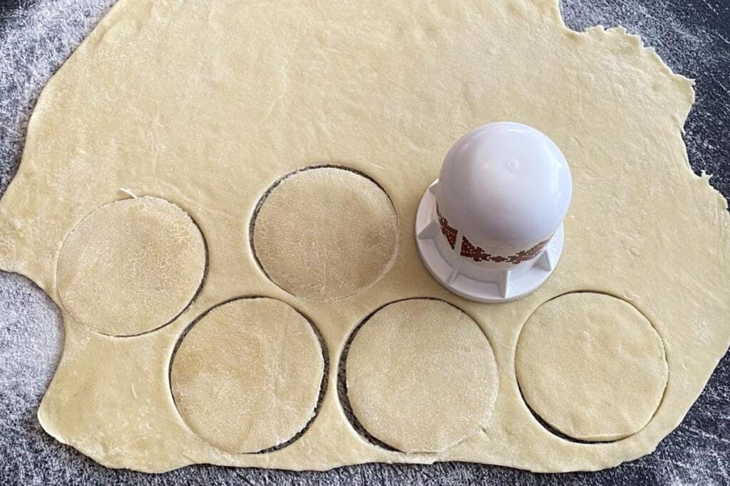 perogy cutter cutting perogy dough into circles on cutting board