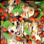 Sheet pan Caprese Chicken on sheet pan with basil and grape tomatoes