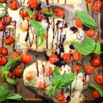 Sheet pan Caprese Chicken on sheet pan with basil and grape tomatoes