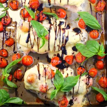 Sheet pan Caprese Chicken on sheet pan with basil and grape tomatoes