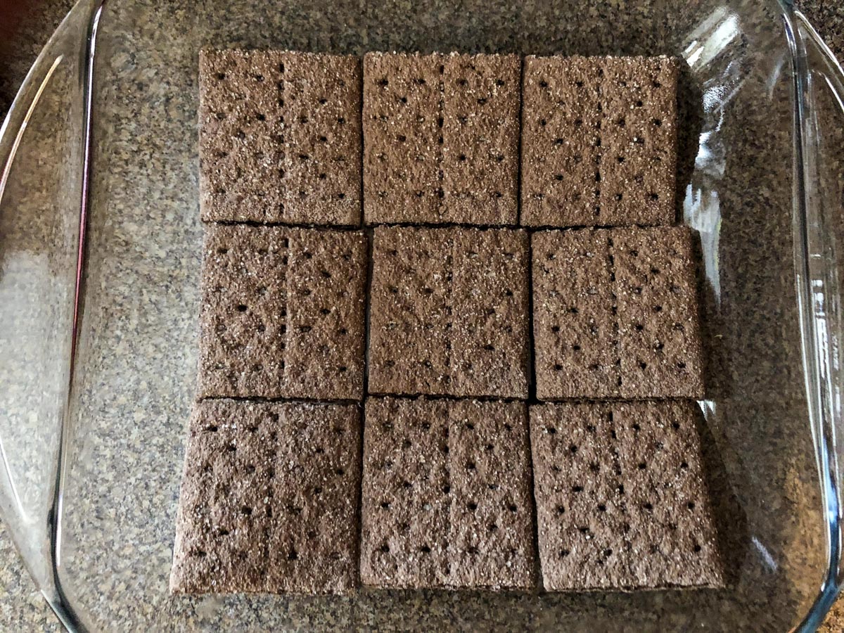 chocolate graham crackers lining the bottom of a 8X8 pan