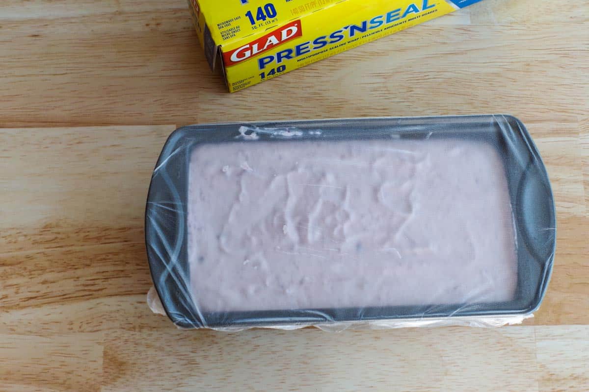 plastic covered loaf pan with ice cream mixture inside
