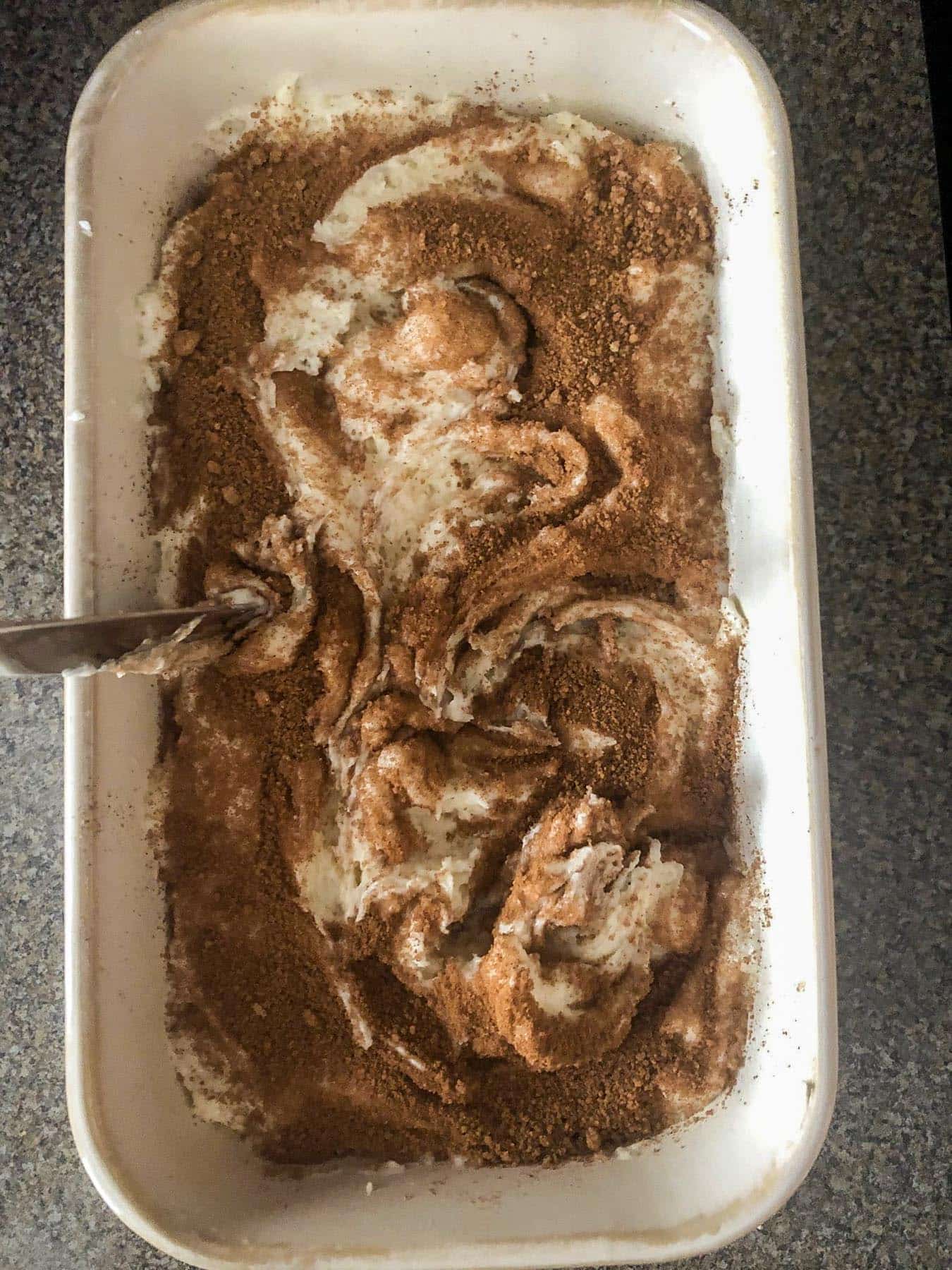 cinnamon brown sugar being mixed in with batter with a knife