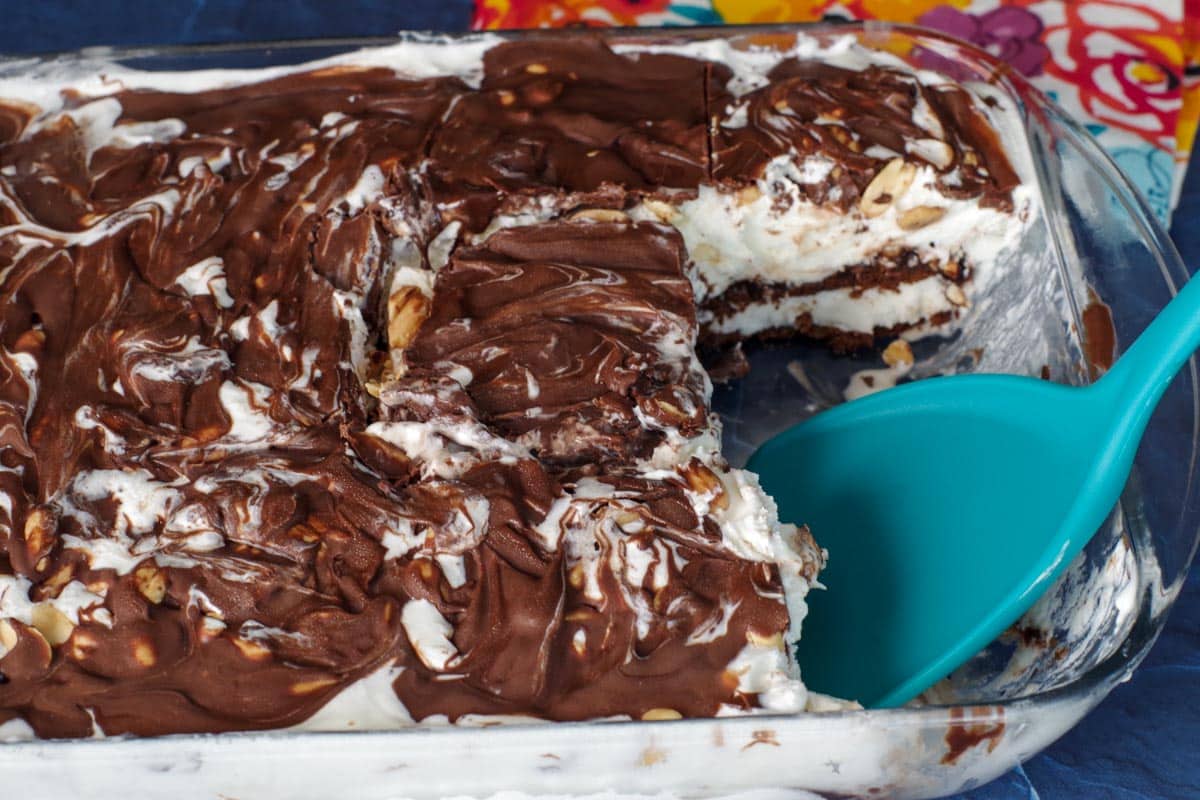 buster bar cake with piece missing, with turquoise spatula in pan