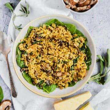 mushroom and spinach rice in a white bowl on white linen