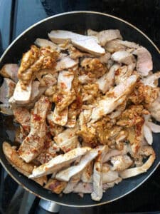 sliced pork with sauce in frying pan