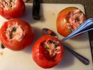 tuna mixture being stuffed back into tomatoes