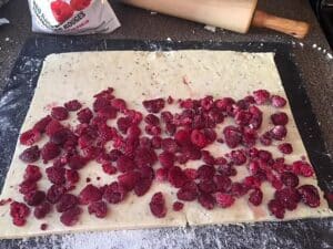 dough cut into rectangle with raspberries on top