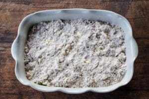 Baking dish with oat mix topping sprinkled on zucchini mixture