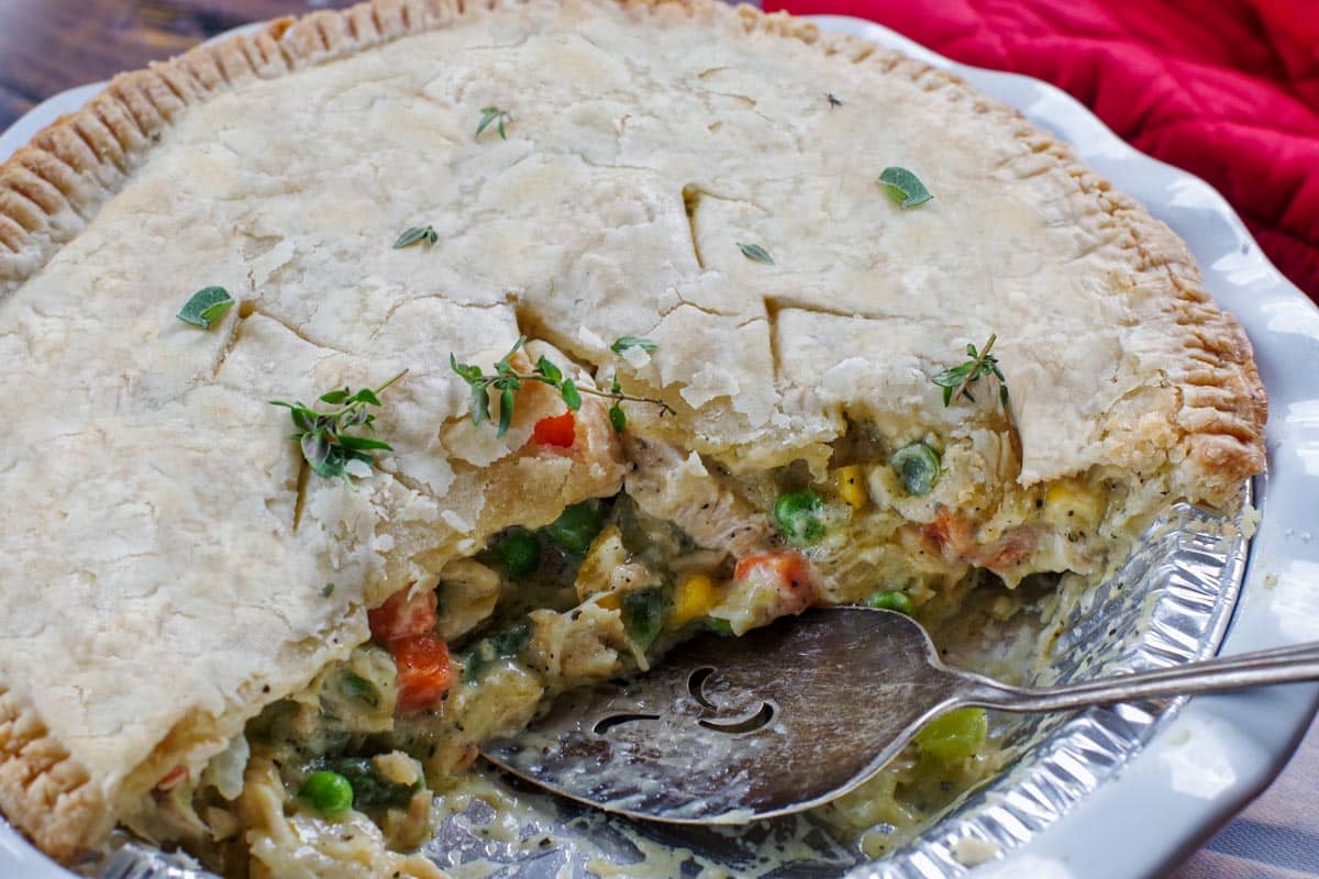 half a turkey pot pie with a pie lifter in the pan