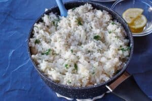 cooked rice in black pot with herbs