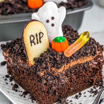 Halloween dirt cake with ghost and tombstone and gummy worm on white plate