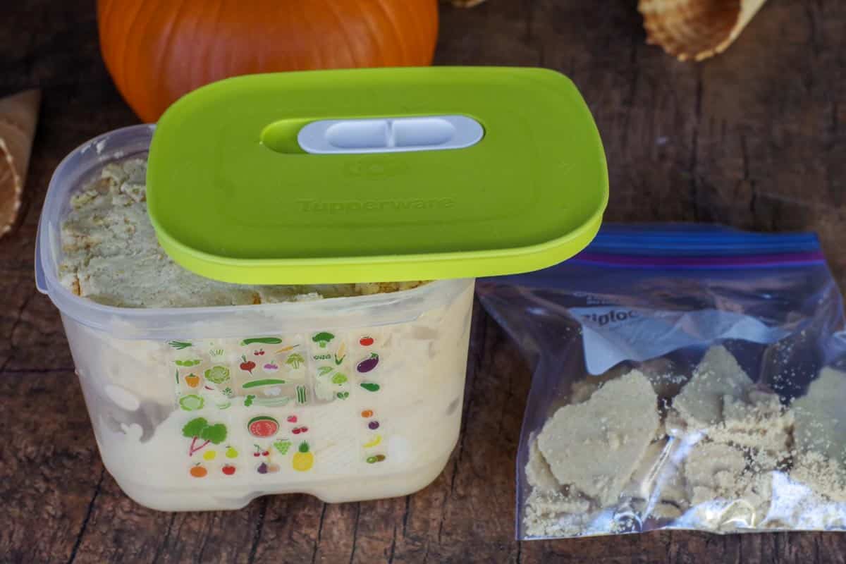 pumpkin ice cream in a clear tupperware container with green lid and bag of graham cracker crust (broken up) in ziploc bag
