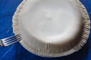 edge of pie being crimped with a fork