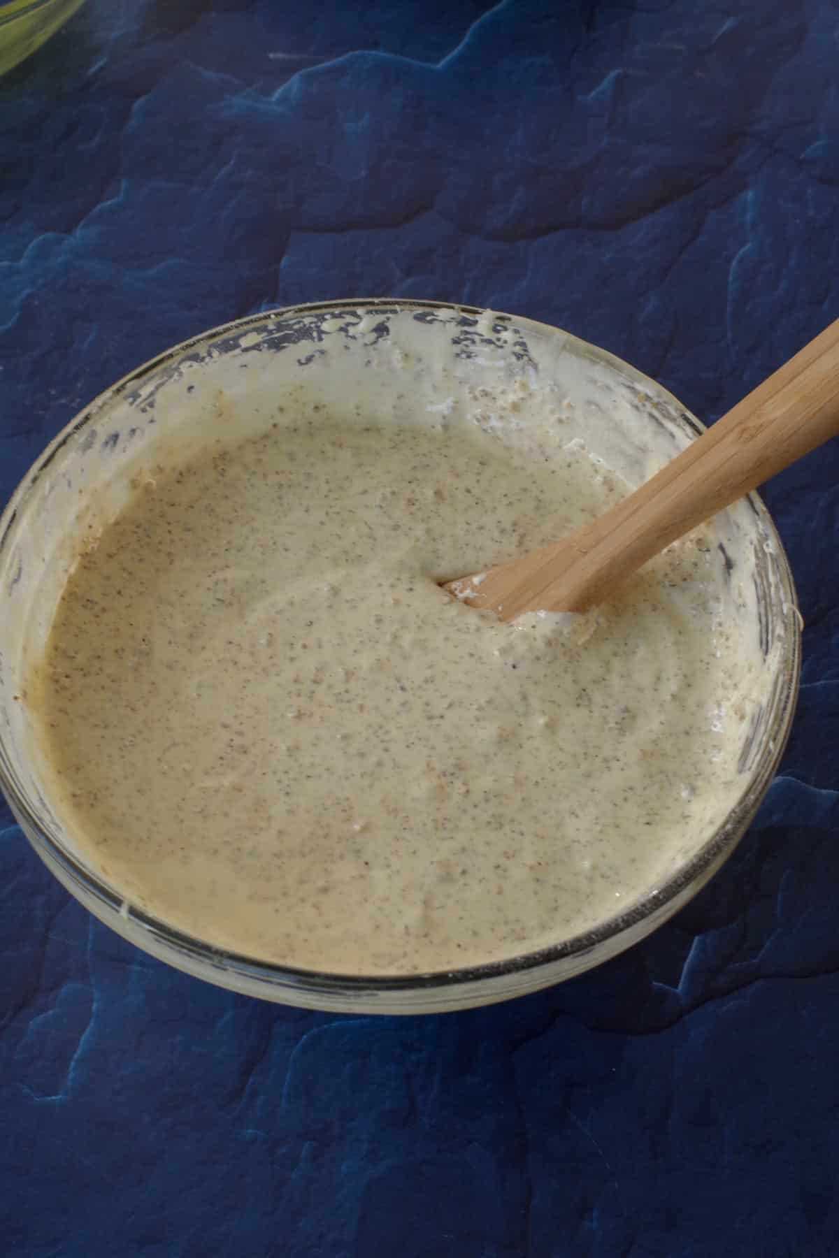walnuts and bread crumbs mixed well into yolk mixture in a glass bowl with wooden spoon