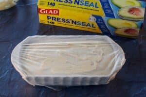 beige ceramic loaf pan covered in plastic wrap