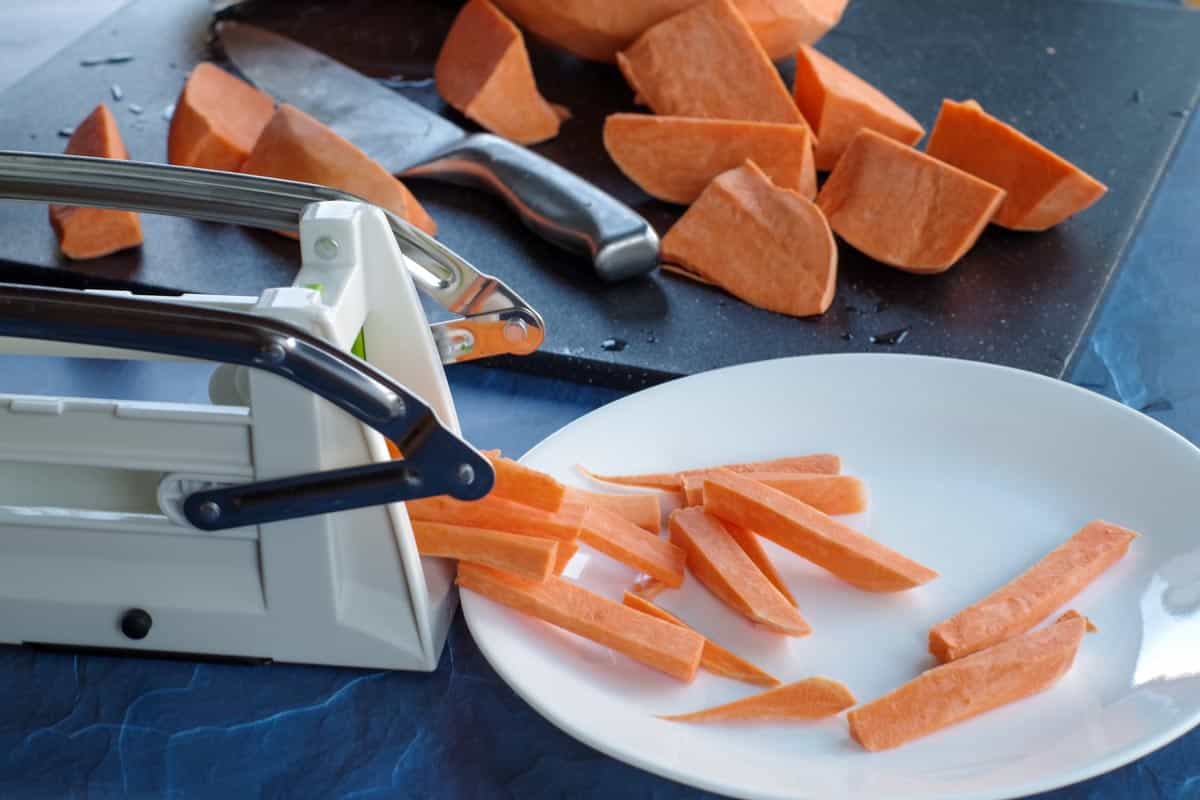 sweet potato fries being cut with a chipper