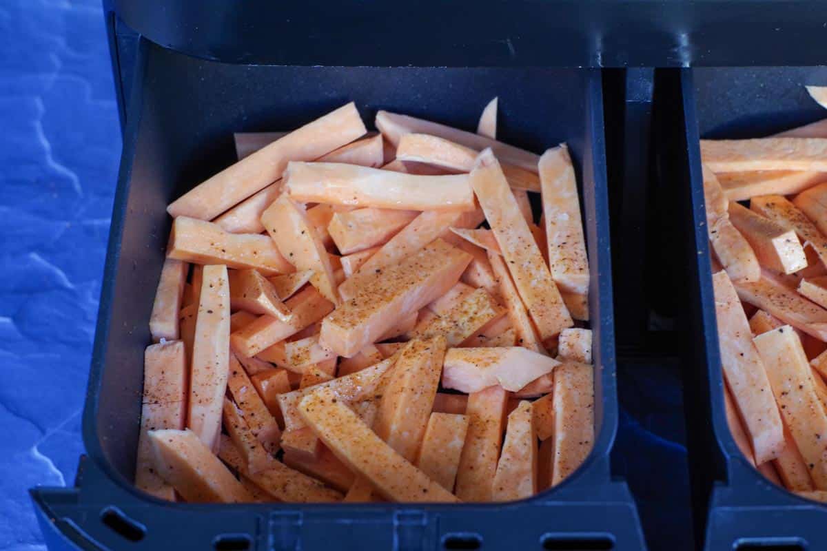 raw sweet potato fries in a drawer of air fryer