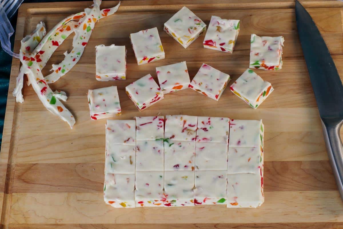 nougat cut into 5 pieces both way, spread on wooden cutting board, with scraps on the side