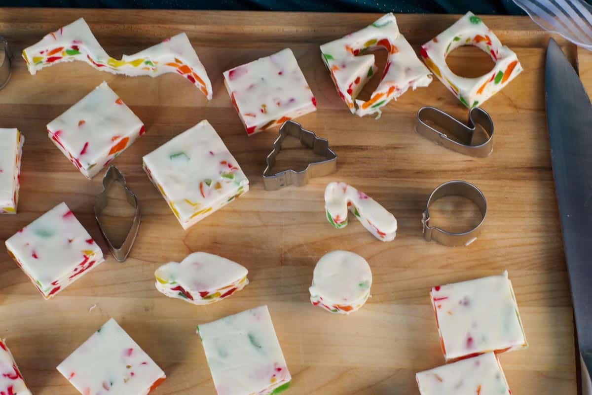 nougat cut into Christmas shapes (candy cane etc) with square s on a wooden cutting board with mini cookie cutters