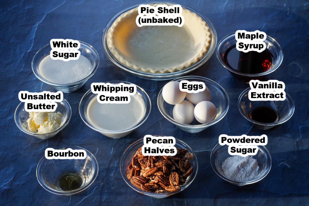 pecan pie ingredients in glass dishes, on blue surface, labelled