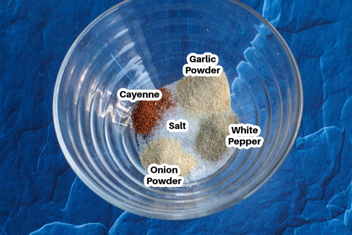 A glass bowl containing spices for sweet potato fries dip spices, labelled with ingredient names