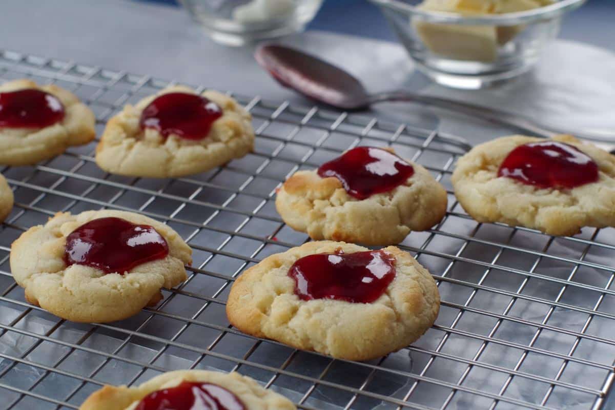 cookies with jam spooned on top, on a cooling rack