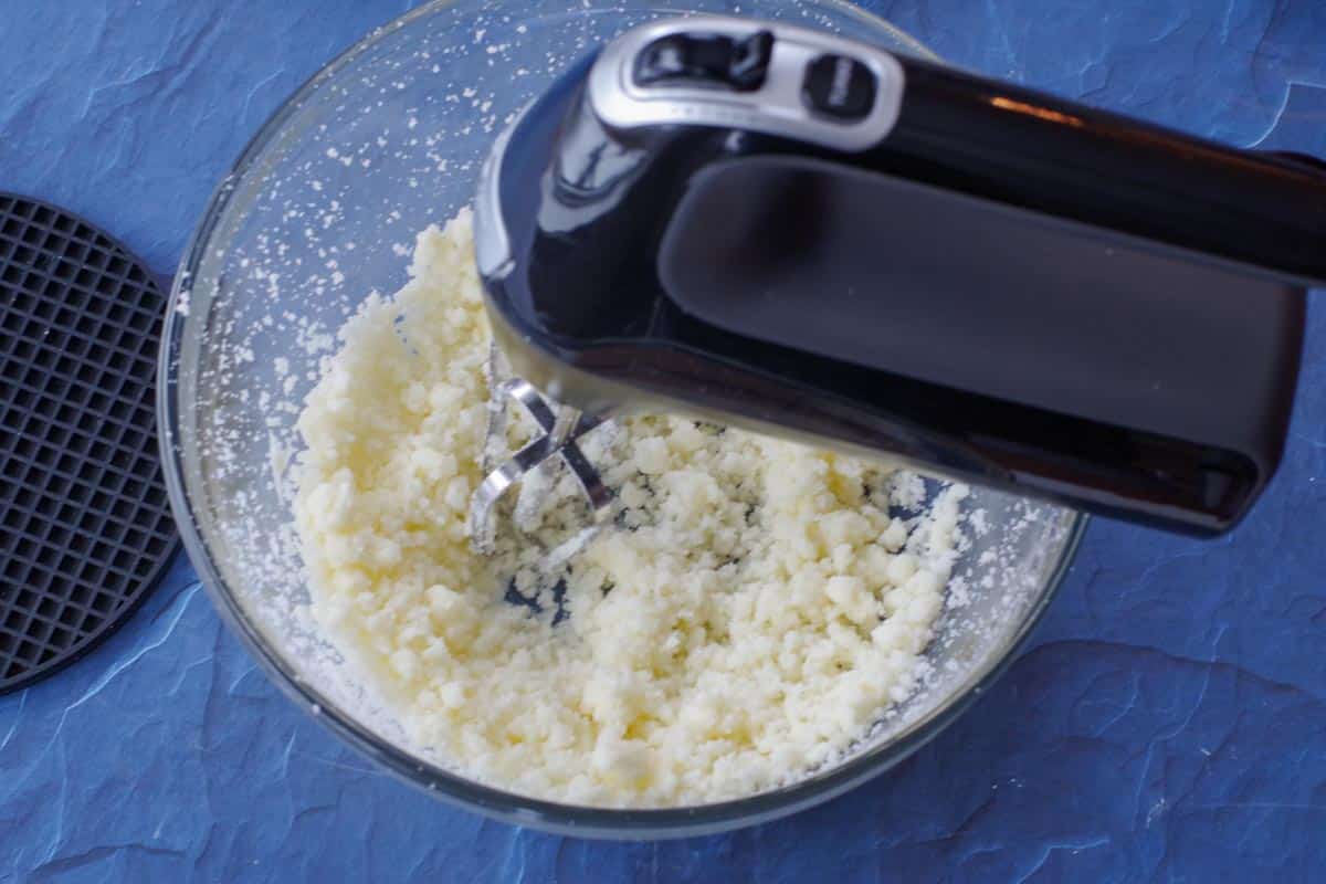 butter with baking soda and salt being beaten with electric mixer