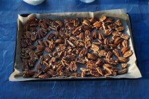 pecan halves on a parchment lined baking sheet