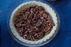 toasted pecans in unbaked pie crust
